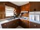 Well-lit kitchen featuring classic wood cabinets, laminate countertops, and modern appliances at 481 Firetower Rd, Louisburg, NC 27549