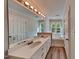 Bright bathroom featuring a double sink vanity, hardwood floors, and a large mirror with Hollywood lights at 4828 Forest Highland Dr, Raleigh, NC 27604