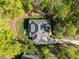 Aerial view of the home featuring a well-manicured lawn, mature trees, and long driveway at 4924 Theys Rd, Raleigh, NC 27606
