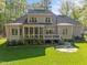 Back exterior of home with screened porch, deck, stone patio, and expansive lawn at 4924 Theys Rd, Raleigh, NC 27606