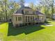 Expansive backyard view of home featuring a screened porch, patio, and lush lawn at 4924 Theys Rd, Raleigh, NC 27606