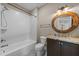 Bathroom featuring a white tub and shower, a rustic-style mirror and a granite countertop vanity at 4924 Theys Rd, Raleigh, NC 27606