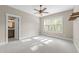 Spacious bedroom with a ceiling fan, large window, plush carpet, and a view of an ensuite bathroom at 4924 Theys Rd, Raleigh, NC 27606