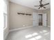 Bright bedroom with ceiling fan, two wooden shelves, plush carpeting, and an adjoining room through double doors at 4924 Theys Rd, Raleigh, NC 27606