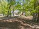 Home surrounded by mature trees, featuring a three-car garage and well-maintained landscaping at 4924 Theys Rd, Raleigh, NC 27606