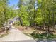 Secluded home nestled among trees with a long driveway and lush landscaping, offering privacy and tranquility at 4924 Theys Rd, Raleigh, NC 27606