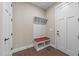 Hallway showcasing a built-in bench with coat rack and storage beneath, complemented by a red cushion seat at 4924 Theys Rd, Raleigh, NC 27606