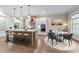 Open kitchen with island seating, stainless appliances, and an adjacent dining area at 4924 Theys Rd, Raleigh, NC 27606