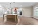 Bright kitchen featuring a large island, stainless steel appliances, and wooden flooring at 4924 Theys Rd, Raleigh, NC 27606