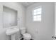 Elegant half bathroom features a pedestal sink, window, and modern fixtures at 51 Landon Pl, Roxboro, NC 27573