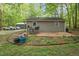 Backyard featuring a patio with outdoor seating, surrounded by lush greenery and mature trees at 6121 Kelvin Dr, Durham, NC 27712