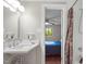 Bright bathroom with a large mirror and vanity, showcasing the doorway to the bedroom at 6121 Kelvin Dr, Durham, NC 27712