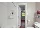 Clean bathroom with tiled shower, recessed storage, and a view into the bedroom at 6121 Kelvin Dr, Durham, NC 27712