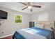 Bright bedroom featuring a ceiling fan, large window, and comfortable bed with a blue quilt at 6121 Kelvin Dr, Durham, NC 27712