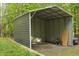 Metal carport structure on a gravel parking pad surrounded by a lawn at 6121 Kelvin Dr, Durham, NC 27712