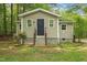 Charming house with tan siding and black door and lots of surrounding trees at 6121 Kelvin Dr, Durham, NC 27712