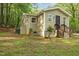View of home with beige siding, dark door, and surrounding landscape at 6121 Kelvin Dr, Durham, NC 27712