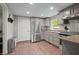 Bright kitchen with stainless steel appliances, gray cabinetry, granite countertops, and hardwood floors at 6121 Kelvin Dr, Durham, NC 27712
