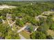 Aerial view of a house with a long driveway, lawn, and tall trees in a green area and other houses at 6907 Field Hill Rd, Raleigh, NC 27603