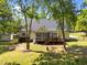 Landscaped backyard featuring mature trees, a deck, and a charming screened-in porch at 6907 Field Hill Rd, Raleigh, NC 27603