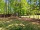 Spacious backyard featuring mature trees and partial fencing at 6907 Field Hill Rd, Raleigh, NC 27603