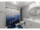 Well-lit bathroom featuring a charming forest-themed shower curtain, white vanity, and built in shelving at 6907 Field Hill Rd, Raleigh, NC 27603