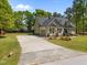 View of the home with a paved driveway leading to an attached garage at 6907 Field Hill Rd, Raleigh, NC 27603
