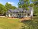 Spacious home featuring a lush green lawn and mature trees in a picturesque setting at 6907 Field Hill Rd, Raleigh, NC 27603