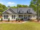 Inviting home with a charming front porch and manicured lawn and neutral color palette at 6907 Field Hill Rd, Raleigh, NC 27603