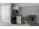 Living room kitchenette boasts white cabinets, granite countertop, microwave, mini fridge, and comfortable armchair at 6907 Field Hill Rd, Raleigh, NC 27603