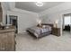 Large bedroom with neutral walls, tray ceilings, a patterned bedspread, and natural light from large windows at 6907 Field Hill Rd, Raleigh, NC 27603