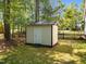 Storage shed in a backyard with a black chain-link fence at 6907 Field Hill Rd, Raleigh, NC 27603