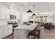 Bright open-concept kitchen featuring a large granite island with bar seating, stainless appliances and an open view to the living room at 716 Ben Ledi Ct, Raleigh, NC 27603