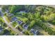 An aerial view showcases a neighborhood with well-kept lawns and a tranquil pond surrounded by lush greenery at 72 Cokesbury Park Ln, Fuquay Varina, NC 27526