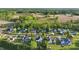 Aerial view of homes with surrounding greenery in a neighborhood, featuring fields and roadways nearby at 72 Cokesbury Park Ln, Fuquay Varina, NC 27526
