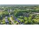 An aerial view shows a serene pond surrounded by lush green trees and well-maintained homes in a charming neighborhood at 72 Cokesbury Park Ln, Fuquay Varina, NC 27526