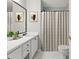 Bright bathroom featuring a white vanity, framed mirror, neutral shower curtain, and marble-look flooring at 72 Cokesbury Park Ln, Fuquay Varina, NC 27526