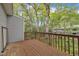 Large outdoor balcony with wooden railings surrounded by lush trees at 7383 Sandy Creek Dr, Raleigh, NC 27615