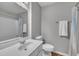 Neutral bathroom with white vanity, toilet, shower/tub combination, and wood look floors at 7383 Sandy Creek Dr, Raleigh, NC 27615