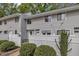 Charming townhouse with gray siding, white picket fence, and a small bench in the front yard at 7383 Sandy Creek Dr, Raleigh, NC 27615