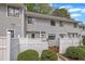 Charming townhouse exterior with white picket fence, well-maintained landscaping, and gray siding at 7383 Sandy Creek Dr, Raleigh, NC 27615