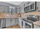 Beautiful kitchen featuring stainless steel appliances, gray cabinets, and a window above the sink at 7383 Sandy Creek Dr, Raleigh, NC 27615