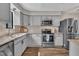 Updated kitchen with stainless steel appliances, granite counters, and light gray cabinets at 7383 Sandy Creek Dr, Raleigh, NC 27615