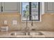Kitchen sink featuring granite countertop, stainless steel faucet, and a sunny window view at 7383 Sandy Creek Dr, Raleigh, NC 27615