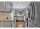 Modern kitchen with stainless steel appliances, gray cabinets, and granite countertops at 7383 Sandy Creek Dr, Raleigh, NC 27615