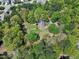 Aerial view of a charming brick home surrounded by lush trees in a quiet neighborhood at 8120 Stillbreeze Dr, Fuquay Varina, NC 27526