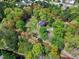 Aerial view of brick home surrounded by lush greenery and mature trees, creating a private and serene setting at 8120 Stillbreeze Dr, Fuquay Varina, NC 27526