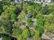 Aerial view of brick home surrounded by lush greenery and mature trees, creating a private and serene setting at 8120 Stillbreeze Dr, Fuquay Varina, NC 27526