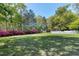 Expansive backyard featuring blooming azaleas and a white picket fence at 8120 Stillbreeze Dr, Fuquay Varina, NC 27526
