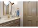 Well-lit bathroom with a beige vanity, a large mirror, and gold fixtures at 8120 Stillbreeze Dr, Fuquay Varina, NC 27526